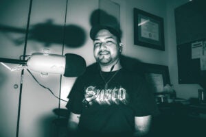 Stylized black-and-white photo of Ayden Castellanos at his microphone